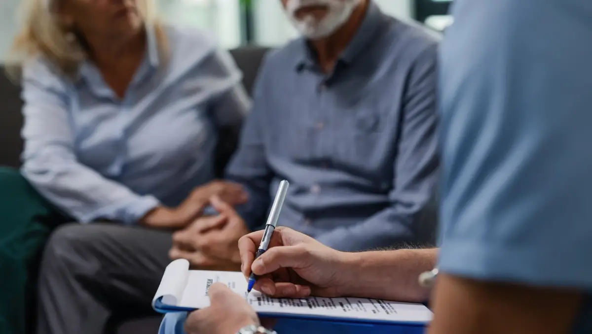 Unrecognizable Male Doctor Writing Medical Report While Visiting Senior Couple Their Home